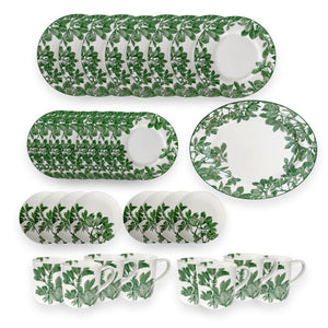 The Caskata Arbor Green Ultimate Set is a 34-piece porcelain dinnerware set with plates, bowls, and mugs, all featuring a green leafy pattern on white. Dishwasher and microwave safe for daily use.