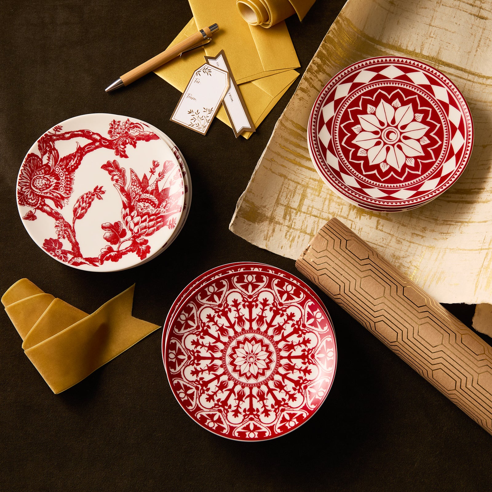 The "Ho Ho Holidays" Bundle by Caskata features three decorative red appetizer plates with intricate patterns—ideal for festive gatherings and holiday entertaining.