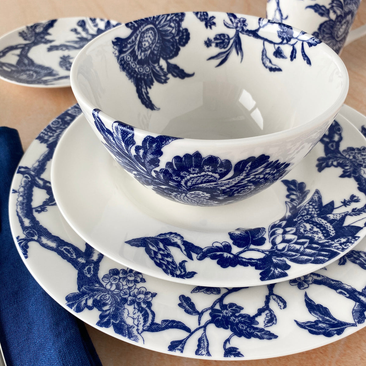 The blue and white porcelain Arcadia 4-Piece Place Setting by Caskata includes dinner, salad, bread and butter plates and cereal bowl.