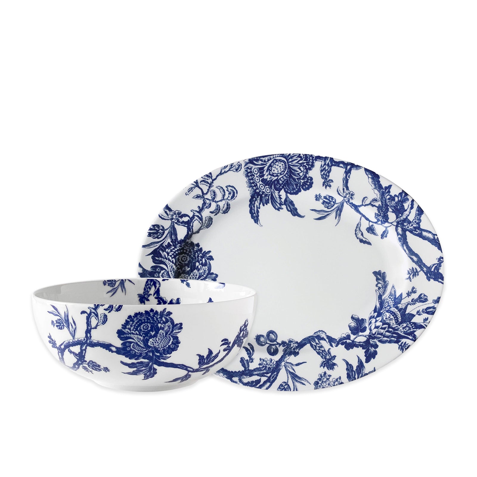 The Caskata Arcadia Serving Set includes a white porcelain bowl and plate with blue floral and vine designs, ideal for elegant serving.