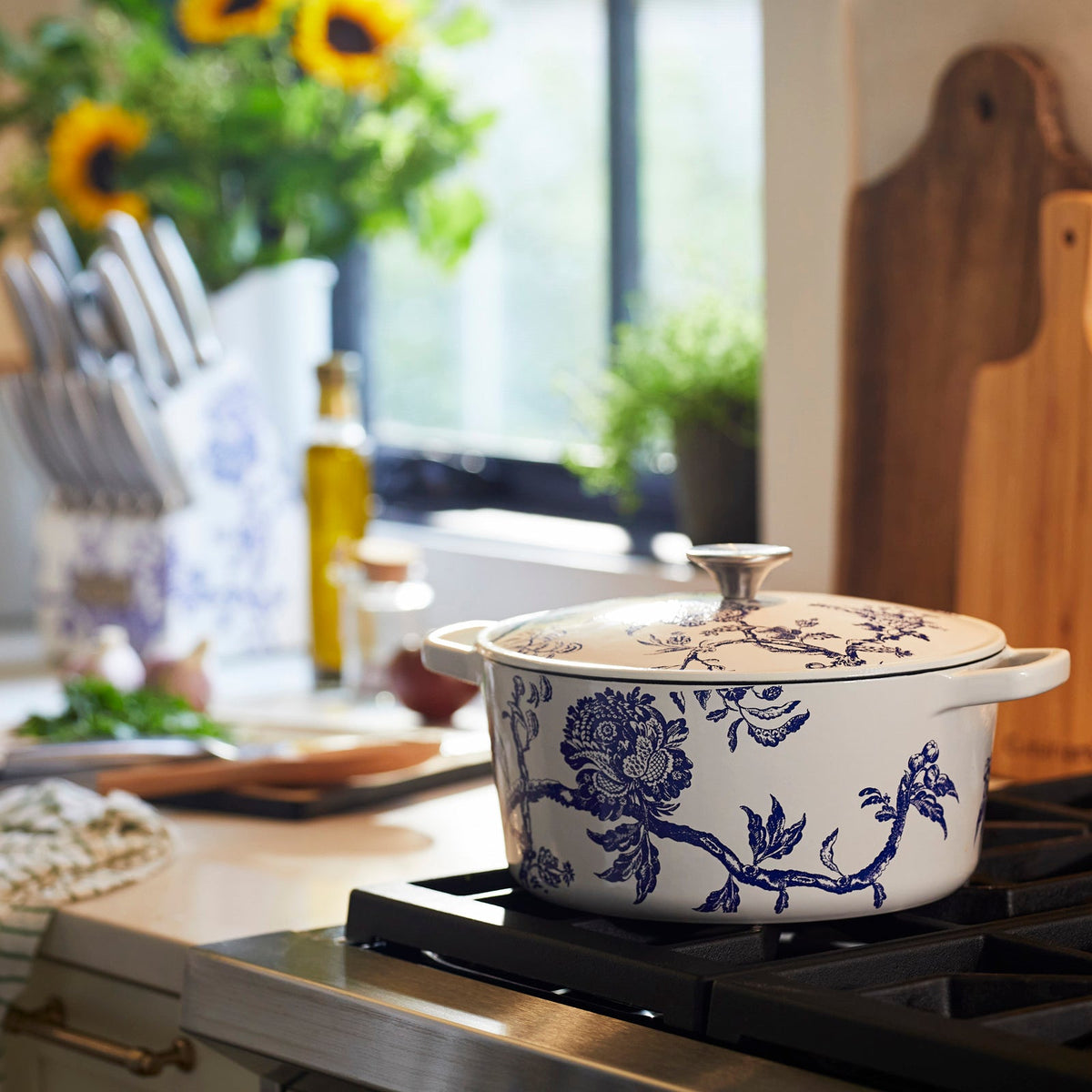 a blue and white Caskata X Cuisinart Limited Edition Arcadia enameled cast iron 5 Qt. round casserole with lid on top of a stove.