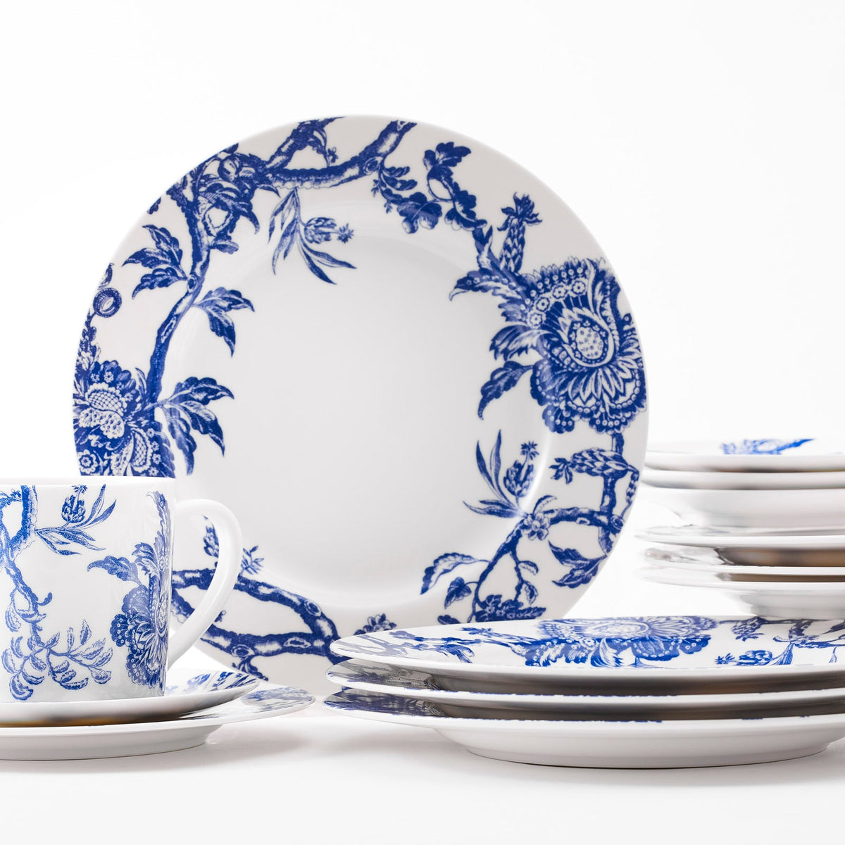 Close up of dinner plates in Arcadia Blue 16 piece dinnerware set. Table for four includs 4 dinner plates, 4 salad plates, 4 canape plates, and four mugs, in high-fired porcelain from Caskata. Dishwasher and Microwave Safe.