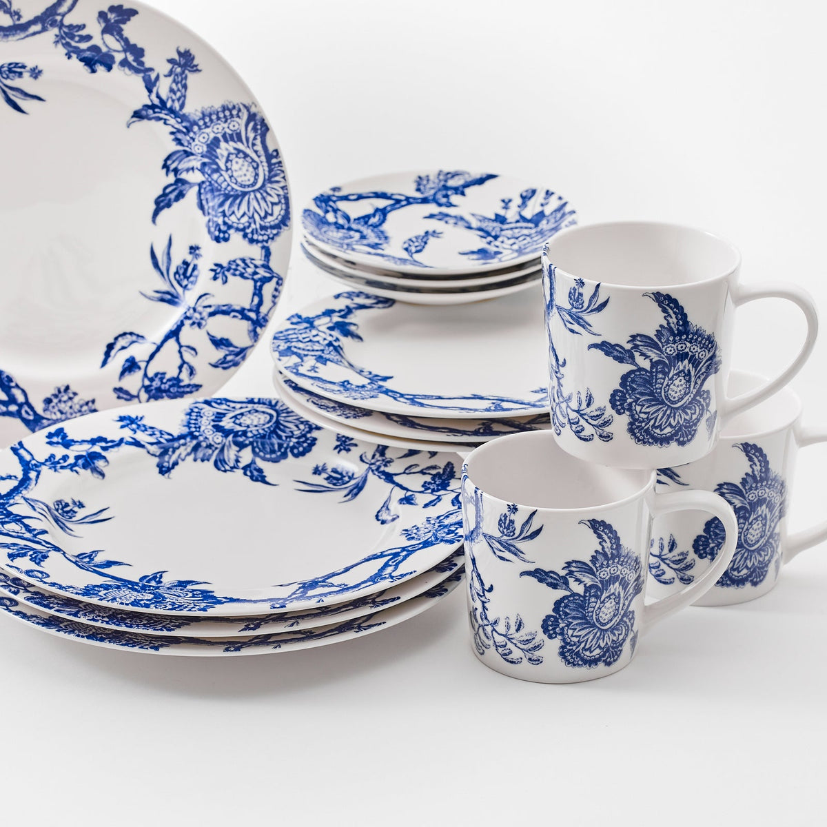 Close up of Arcadia Blue 16 piece dinnerware set. Table for four includs 4 dinner plates, 4 salad plates, 4 canape plates, and four mugs, in high-fired porcelain from Caskata. Dishwasher and Microwave Safe.