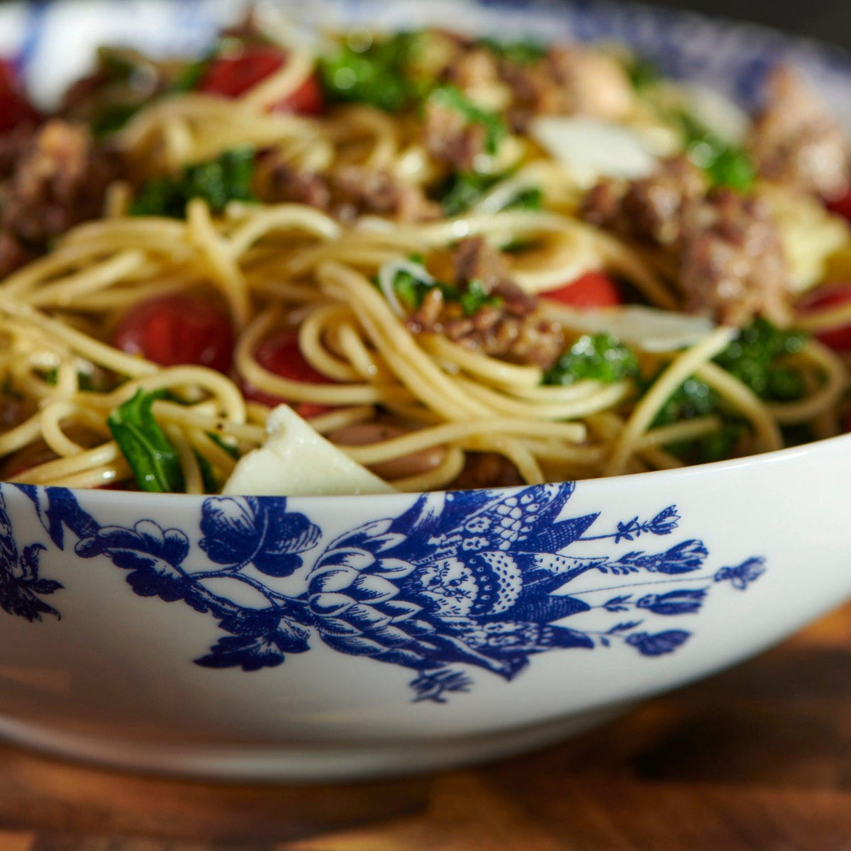 A bowl of spaghetti with sausage and kale served in a Arcadia Wide Serving Bowl by Caskata Artisanal Home.