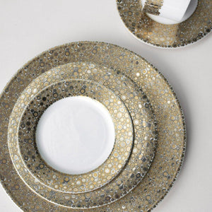 A set of elegant Ellington Shimmer Gold & Platinum Salad Plates by Caskata Artisanal Home on a table radiating the precious metals' luster, creating an exquisite harmony.