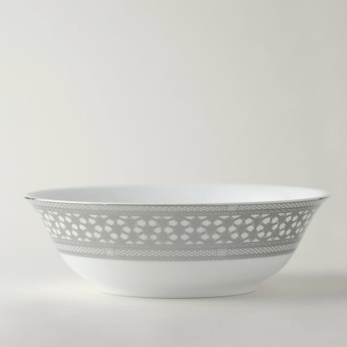 A Hawthorne Ice Platinum Medium Serving Bowl with a silver pattern on it, perfect for serving meals or displaying decorative items. (Brand Name: Caskata Artisanal Home)