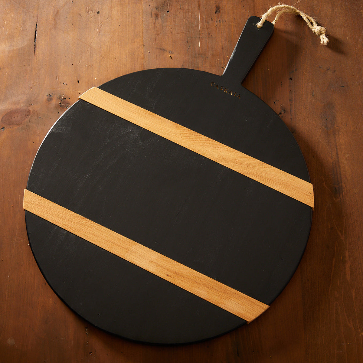 A versatile Black &amp; Natural Round Charcuterie Big Board by Etu Home on a wooden table, perfect for holiday entertaining.