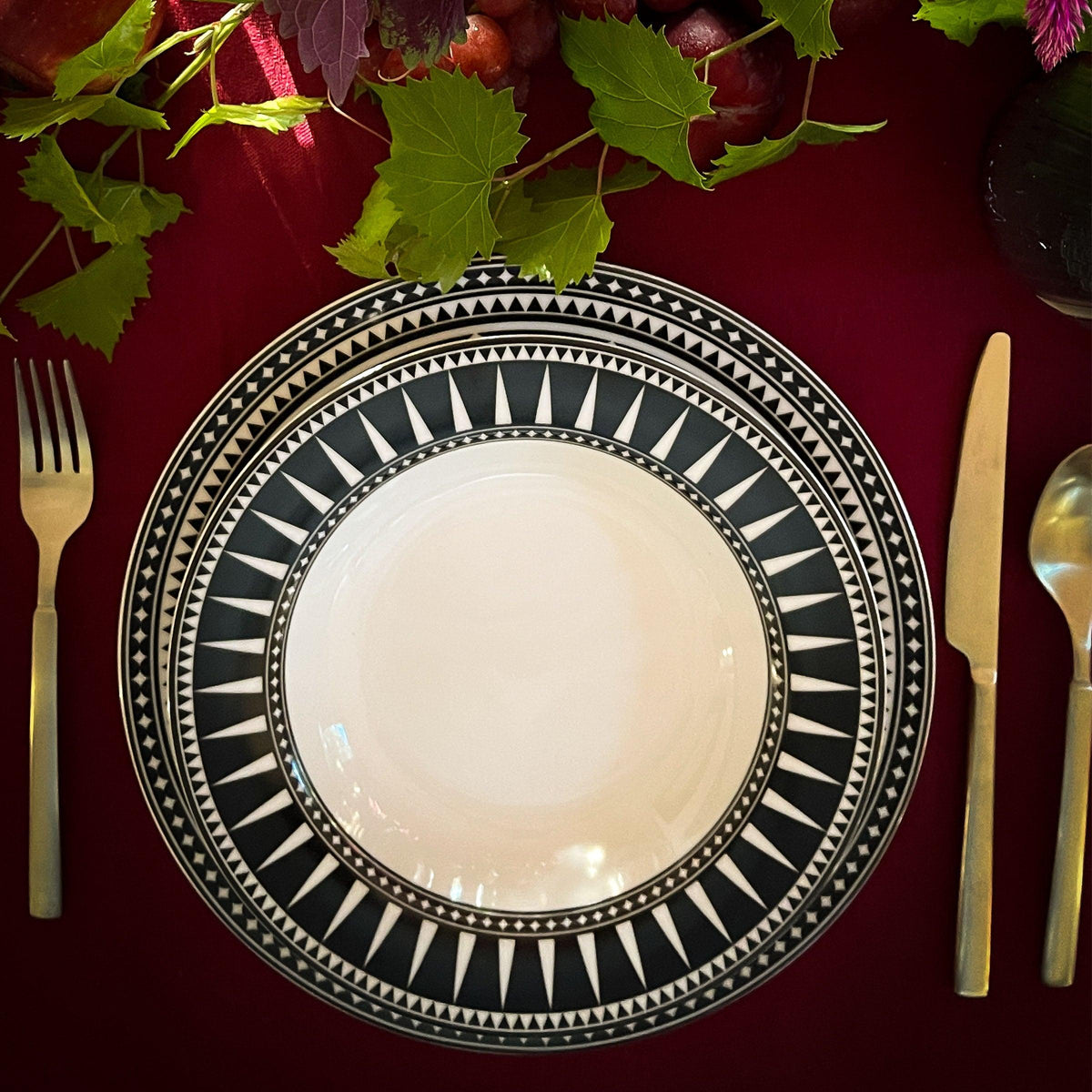 A table setting featuring a Marrakech Rimmed Soup Bowl from Caskata Artisanal Home and silverware.