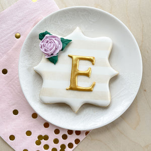 A decorative sugar cookie with a gold 