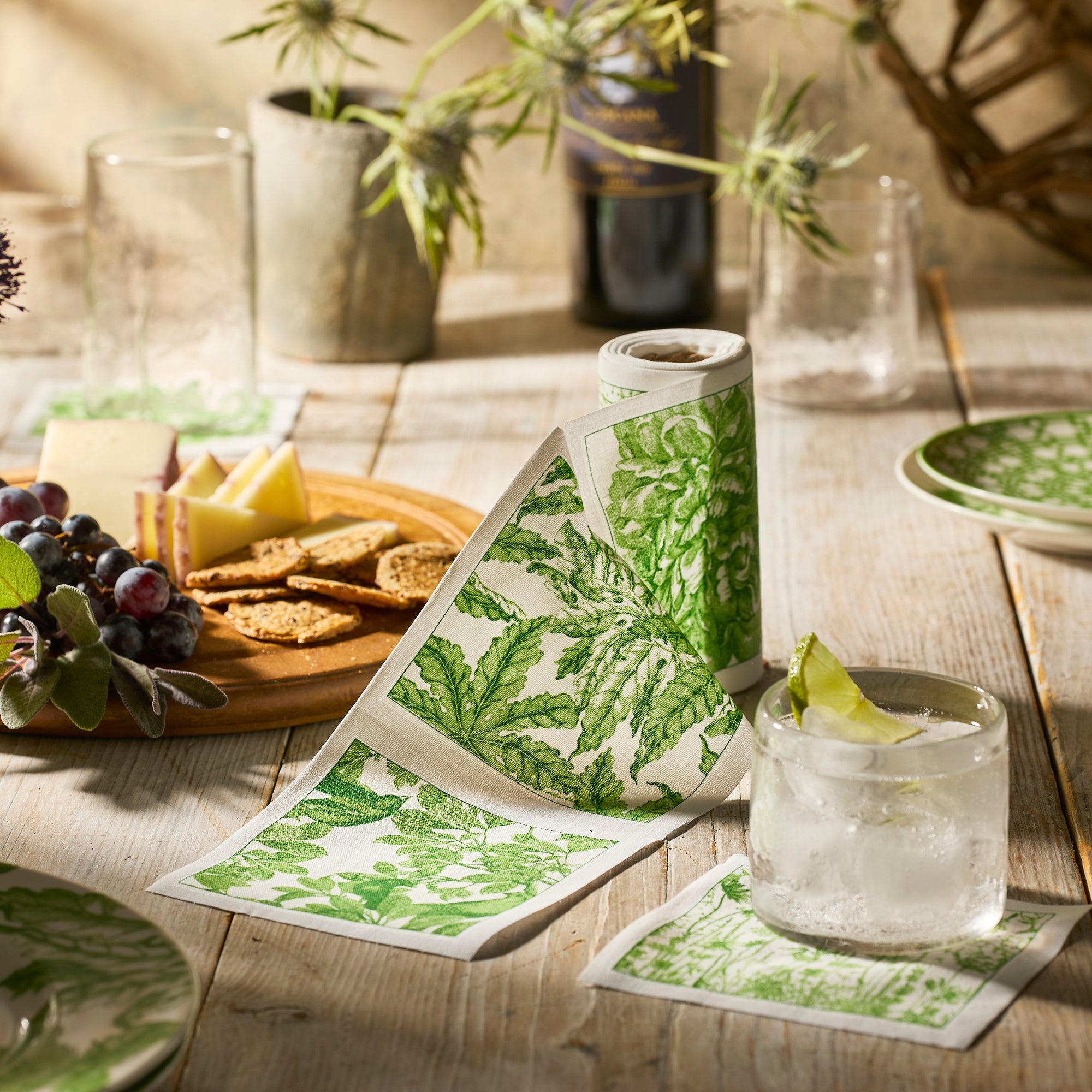 The MY DRAP Botanicals Verde Cocktail Napkin Roll features green botanical prints, adding an elegant touch to your table—ideal for pairing with floral décor or cocktail napkins.