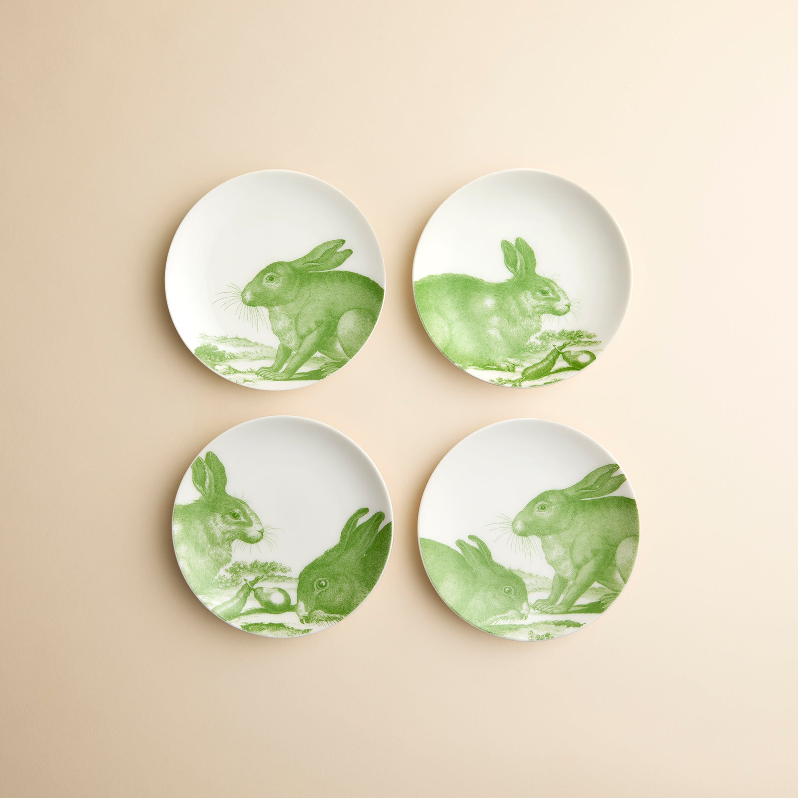 4 different vibrant green rabbit engravings adorn this set of 4 porcelain small plates from Caskata in the Bunnies Green pattern.