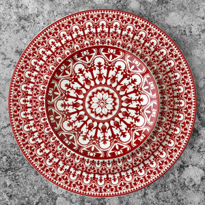 A Casablanca Crimson Salad Plate from Caskata Artisanal Home, with an ornate pattern, made of premium porcelain dinnerware that is dishwasher and microwave safe.