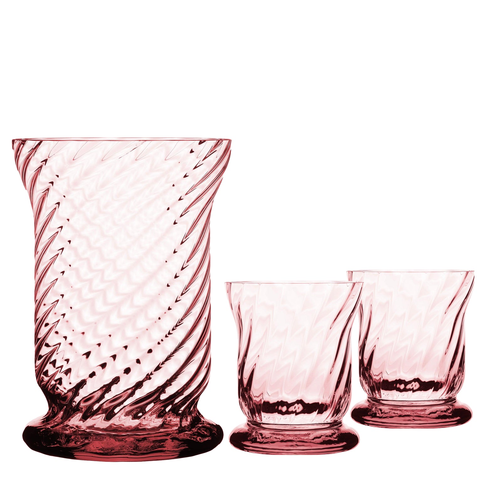 The Quinn Rose Candlelight Bundle by Caskata features three pink glass tumblers with a spiral pattern, crafted from mouth-blown Czech Republic lead-free crystal, including two smaller and one larger piece, elegantly displayed against a white background.