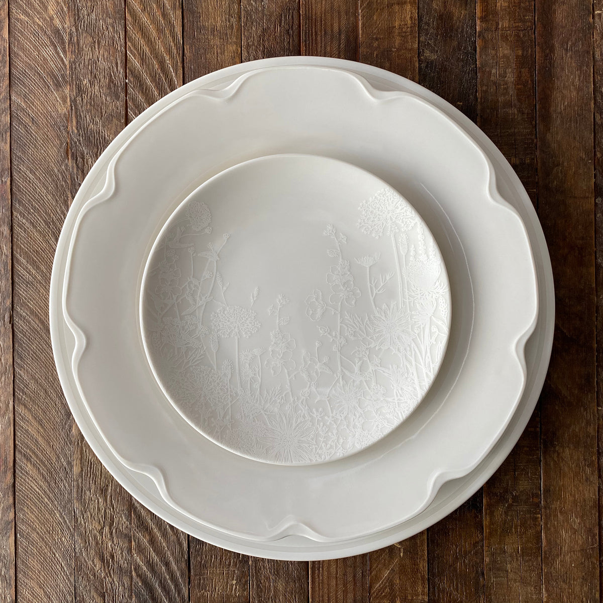 A Summer White Canapé Plates from Caskata Artisanal Home on a wooden table.