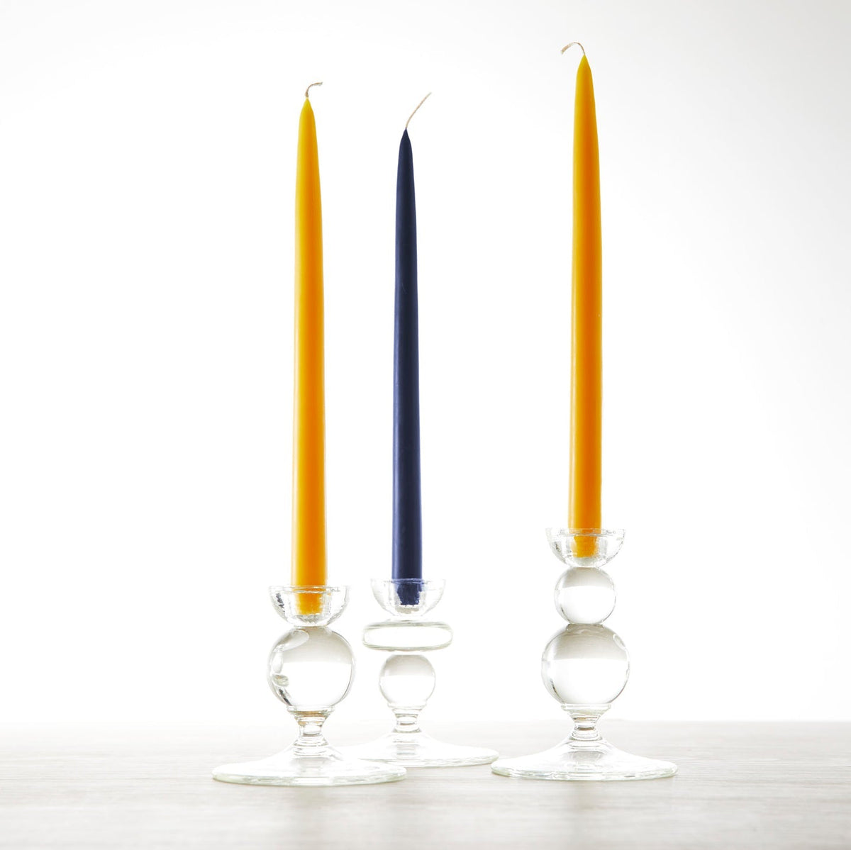 Three glass candle holders with 12&quot; Marigold Taper Candles - Set of 2 from Floral Society, perfect for a summer setting.
