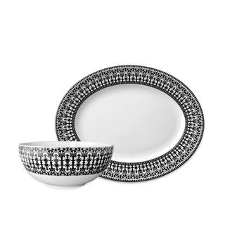 The Caskata Casablanca Serving Set includes a porcelain bowl and oval plate with elegant black scrollwork-inspired borders.