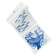 A rolled-up Coastal Cocktail Napkin Roll by MY DRAP with blue illustrations of fish and an octopus, perfect as a beach-lover's gift.