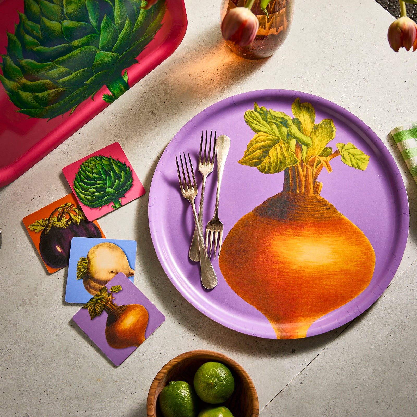 Caskata's Veggies Birchwood Coasters feature artichoke on pink, turnip on blue, eggplants on orange, and rutabaga on purple, each illustrated on environmentally sensitive birchwood trays.
