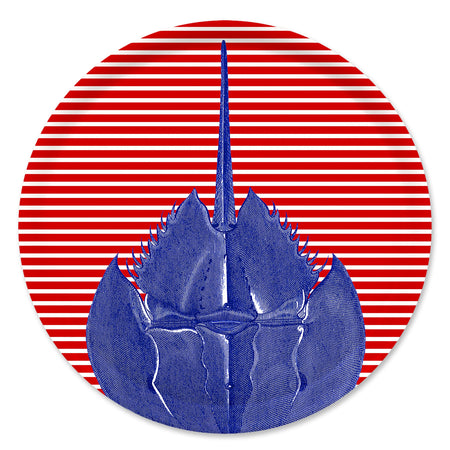 The Caskata Horseshoe Crab Large Round Birchwood Tray features a blue horseshoe crab on a red and white striped circular background, echoing vibrant Finnish design.