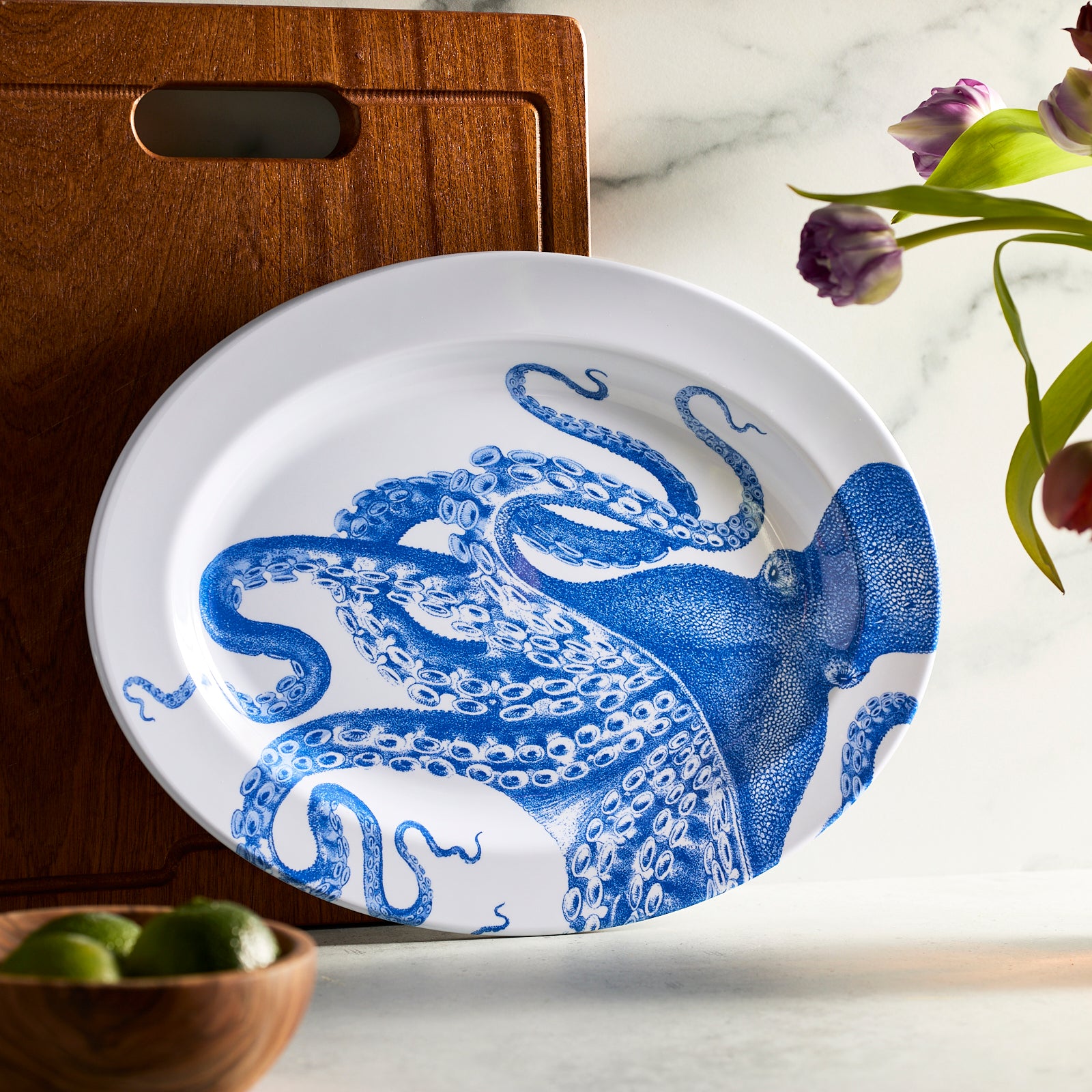 The Caskata Lucy "Dinner is Served" Melamine Bundle features BPA-free dinnerware that combines unbreakable style with elegance, showcasing white plates and bowls with detailed blue octopus illustrations.