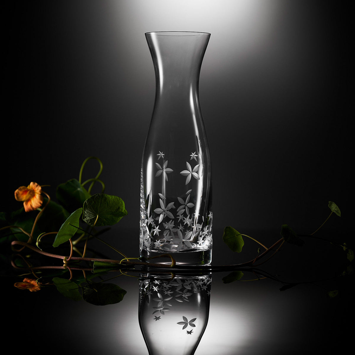 A Chatham Bloom Carafe adorned with flowers, inspired by retro shapes. Perfect for Caskata Collection enthusiasts or adding a touch of elegance to New England lawn parties.