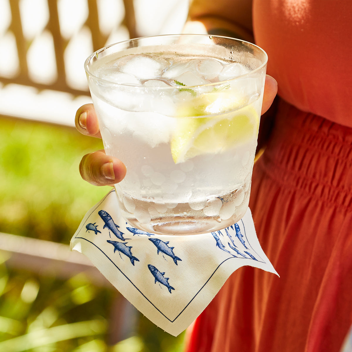 A woman holding a glass of water with Chatham Pop Tumblers by Caskata.