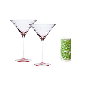 The Cheers to You Bundle by Caskata features two pink crystal martini glasses with pink bases alongside a green and white patterned cylindrical container, creating a chic hostess gift on a white background.