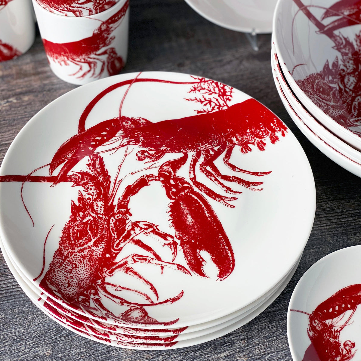 A set of Lobster Red Coupe Dinner Plates by Caskata, perfect for a seaside style.
