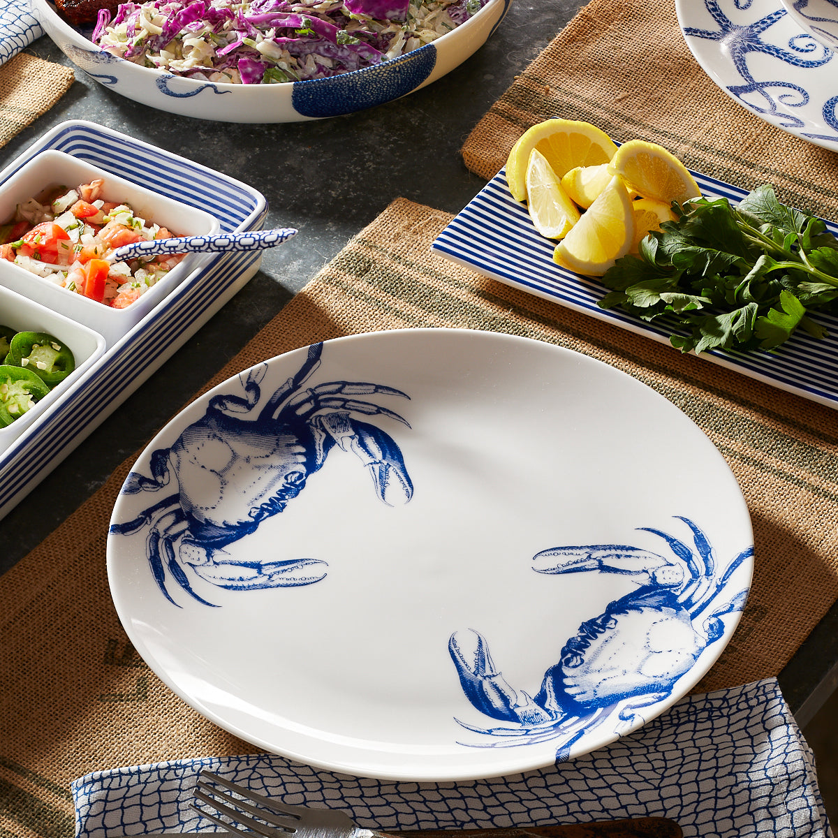 A set of Crab Coupe Dinner Plates by Caskata Artisanal Home with crabs on them.