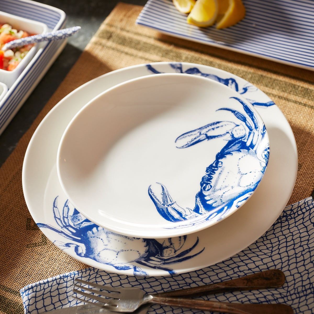 A Crab Coupe Dinner Plate by Caskata Artisanal Home with a crab on it.