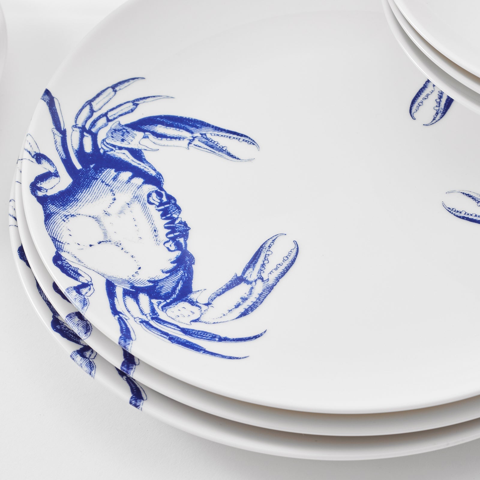 A blue and white Crab Table for 4 dinner plate set with crabs on it by Caskata.