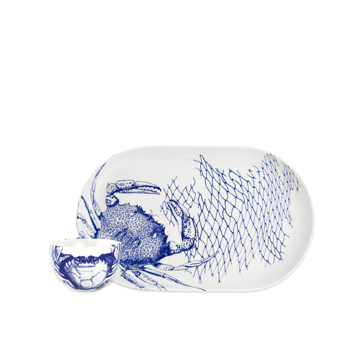 The Caskata Crab Crudité Set features a white porcelain platter and small bowl with blue crab and net illustrations—perfect coastal dinnerware or a charming addition to seaside decor.