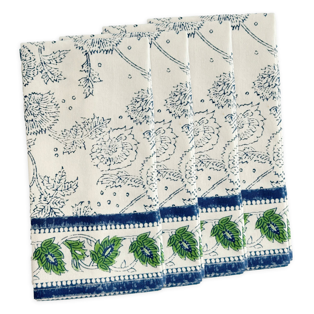 Caskata’s Cuttyhunk Block Print Dinner Napkins feature blue floral patterns and a green-blue leaf border—four folded cotton napkins, slightly overlapping, ideal for a stylish bohemian table setting.