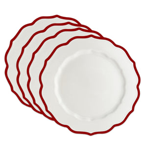Four Caskata Stella Scalloped Crimson Dinner Plates are stacked with slightly overlapping scalloped edges and red trim, highlighting their classic elegance.
