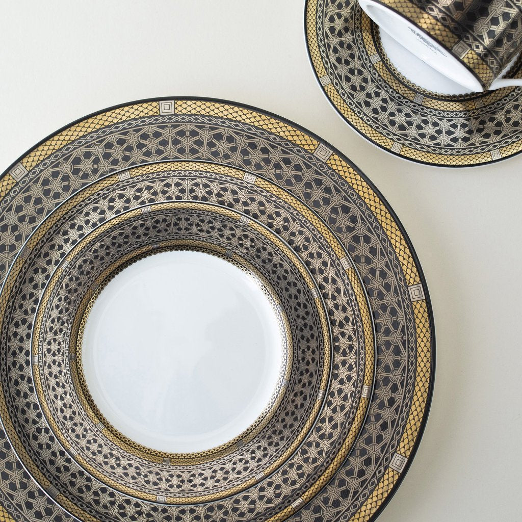 A Hawthorne Onyx Gold &amp; Platinum Dinner Plate and saucer by Caskata Artisanal Home on a white surface.