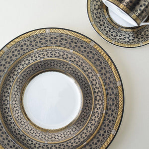A Hawthorne Onyx Gold & Platinum Dinner Plate and saucer by Caskata Artisanal Home on a white surface.