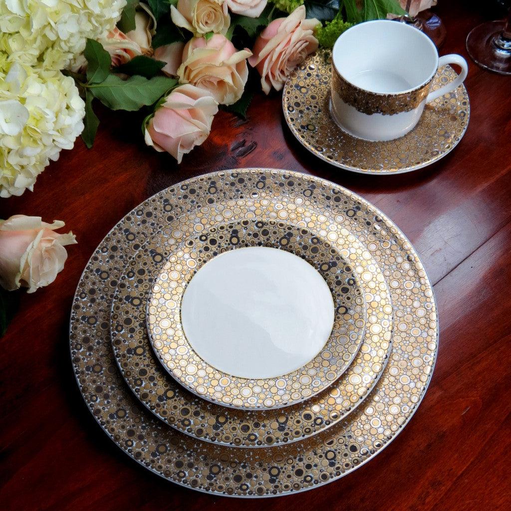 A set of Ellington Shimmer Gold &amp; Platinum Cup &amp; Saucer by Caskata Artisanal Home on a wooden table.