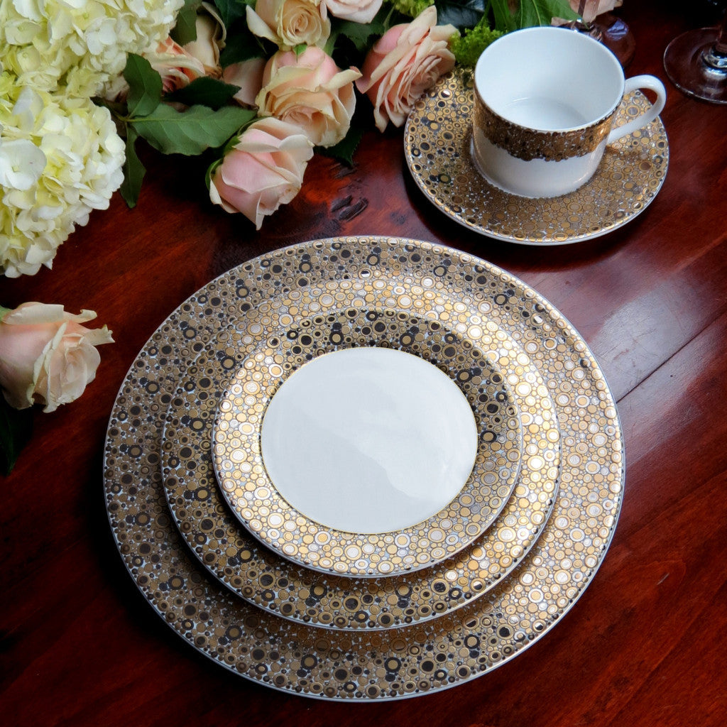 A set of Ellington Shimmer Gold &amp; Platinum Dinner Plates by Caskata Artisanal Home shimmering on a table.