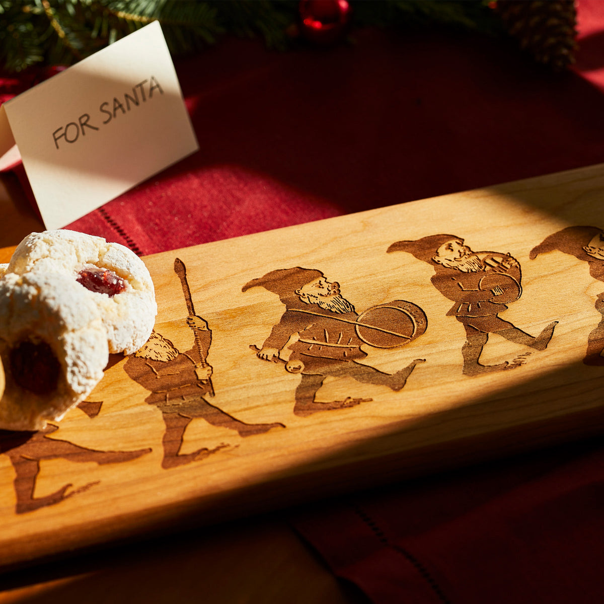 An Elves Serving Board with a holiday whimsy Santa Claus design by Caskata.