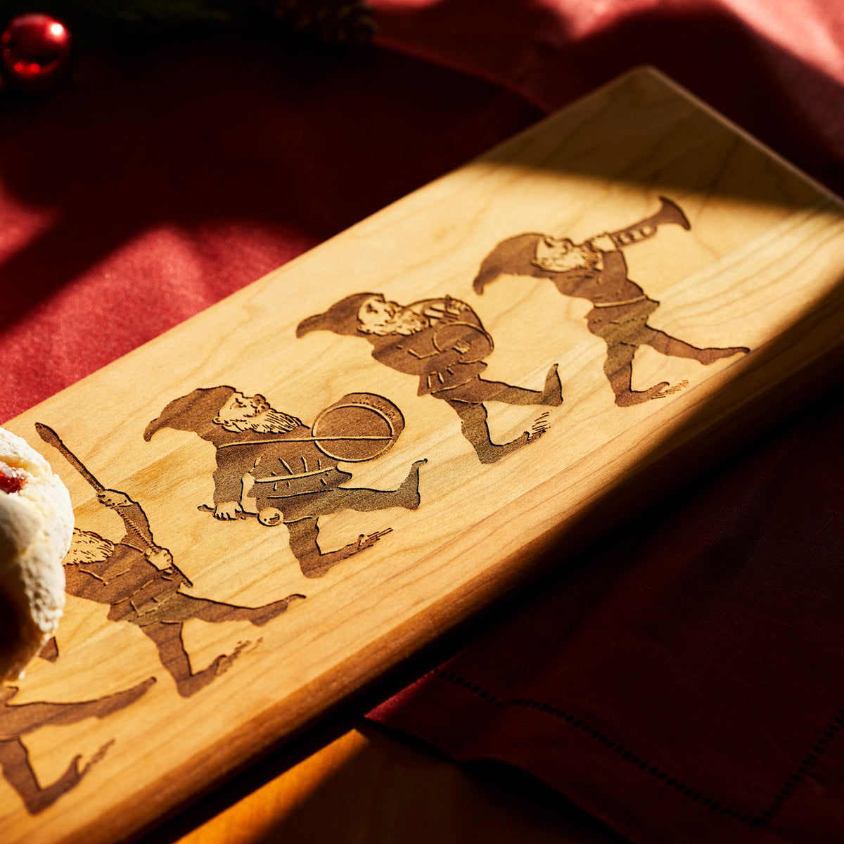 A Caskata Elves Serving Board with a picture of a holiday whimsy group of gnomes.
