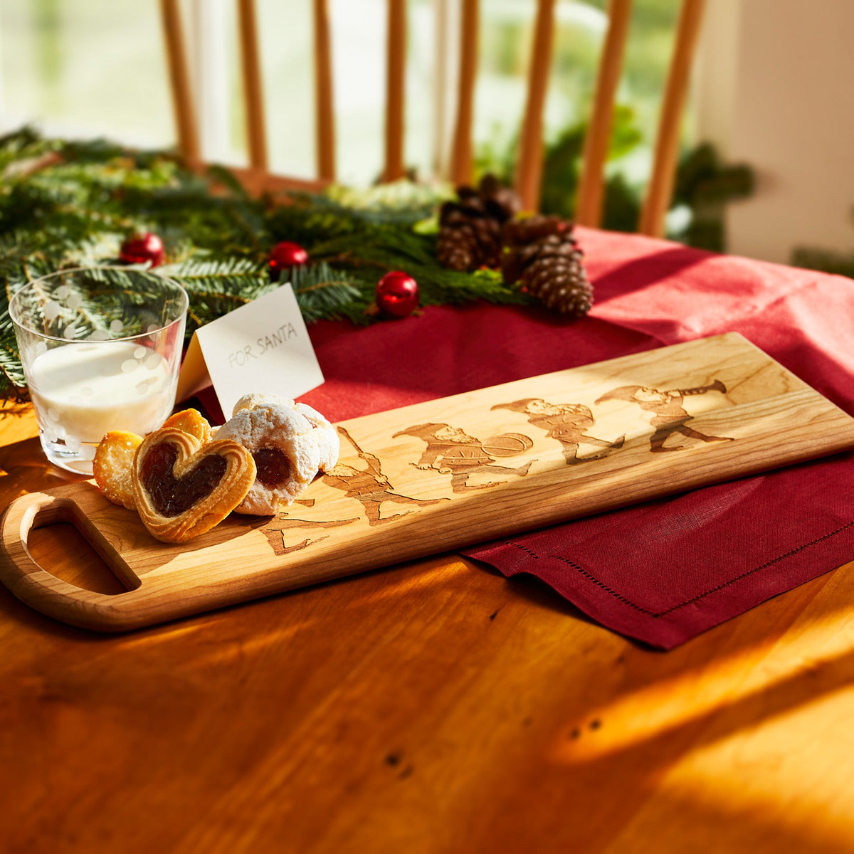A Caskata Elves Serving Board with cookies and a glass of milk.