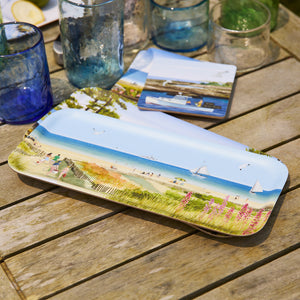 The Caskata X Felix Doolittle Beach Dunes Small Rectangular Tray is shown on a wooden outdoor table with blue and green glassware and a matching coaster—ideal for summer home decor.