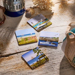 The Caskata X Felix Doolittle Summer Birchwood Coasters, Set of 4, are arranged on a sandy wood surface with shells and a netted bag, capturing New England summer charm.