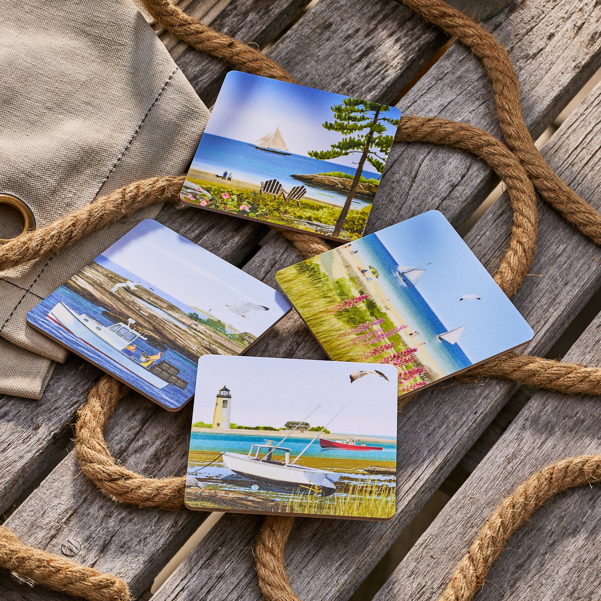 The Caskata X Felix Doolittle Summer Birchwood Coasters, a set of 4 from Caskata, display beach and seaside scenes on birchwood melamine—perfect for evoking New England summer charm.