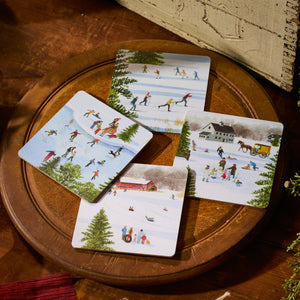 The Caskata X Felix Doolittle Winter Birchwood Coasters, Set of 4, by Caskata features winter scenes of skating and snow play, arranged on a round birchwood tray. Made in Finland.