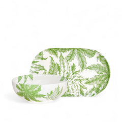 The Caskata Freya Serving Set includes a ceramic vegetable bowl and large oval platter, both decorated with green leaf patterns on white.