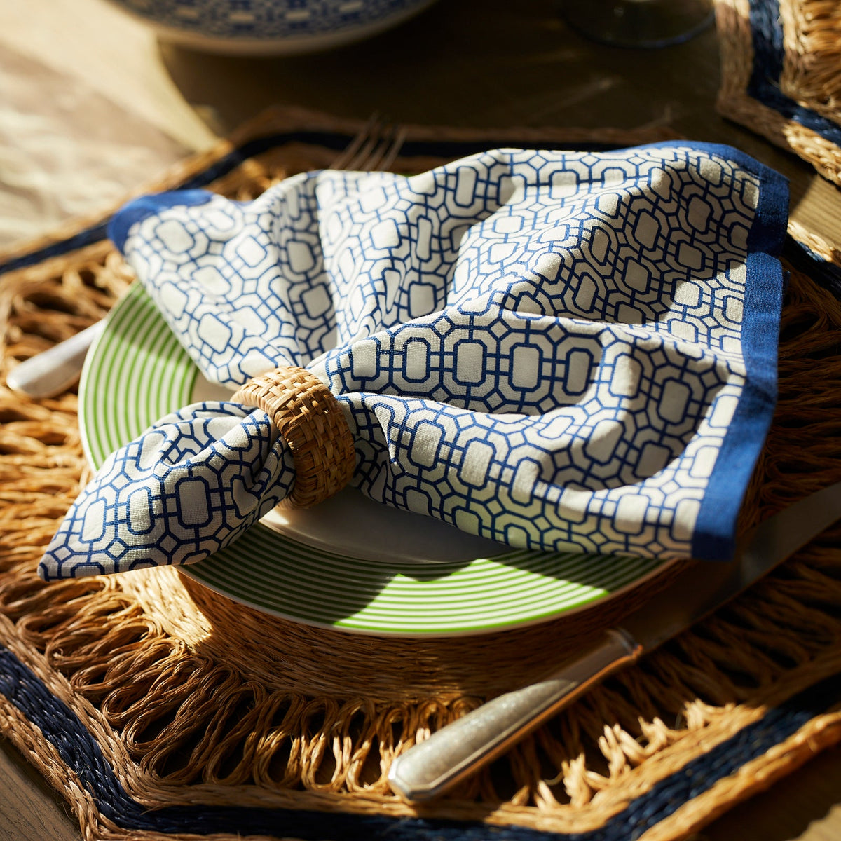 A Newport Garden Gate Dinner Napkin in Blue Set/4 on a plate brand Caskata.