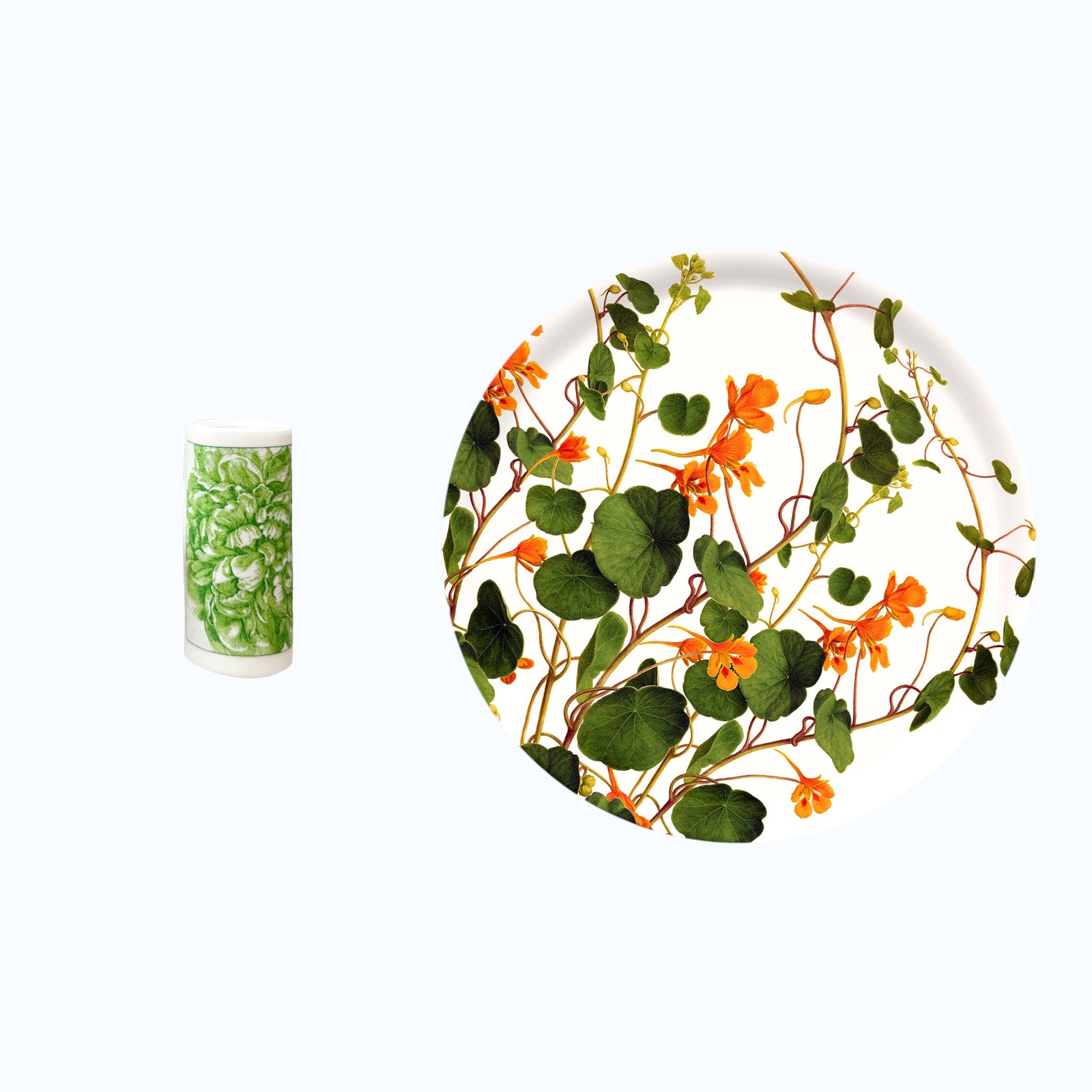 A white plate with an orange and green floral pattern sits beside a tall glass filled with greens, both on a white background—the perfect accents for your Caskata Gardener's Essentials Bundle.