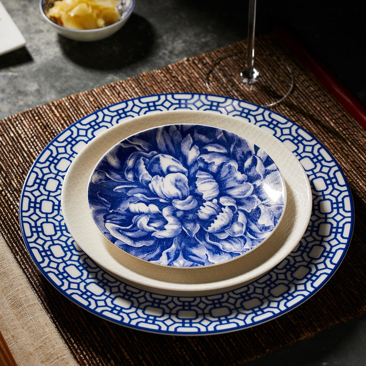 A stack of Peony Canapé Plates, from the Caskata Artisanal Home brand, on a table.