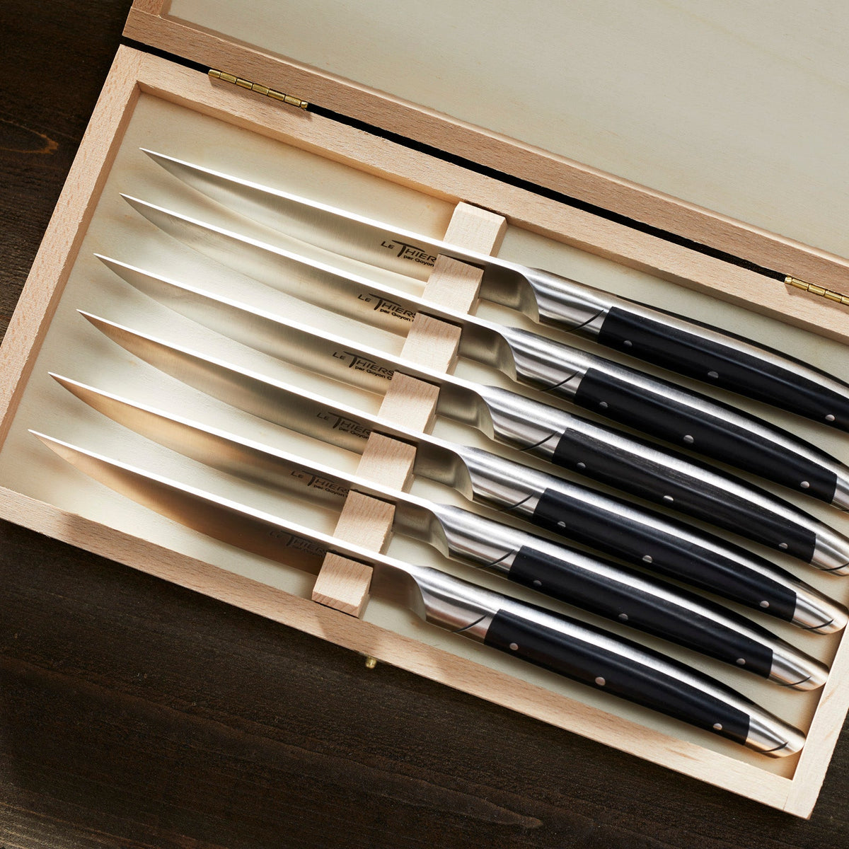 A set of Goyon-Chazeau Black Paperstone Steak Knives Boxed Set/6 in a wooden box.